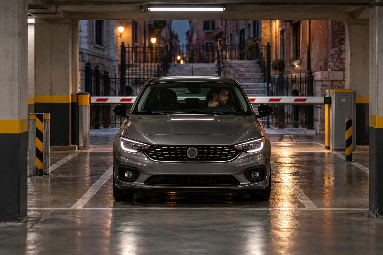A grey Fiat Tipo parked in a Venice parking garage with the driver inside waiting at the exit barrier