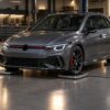 Grey performance hatchback parked on electronic corner weight scales inside a professional tuning garage